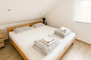 a bedroom with two beds with white sheets and pillows at STAY - Seeblick Apartment in Friedrichshafen