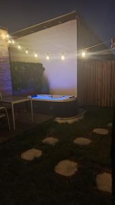 a backyard with a pool and a table and lights at Maisonnette des trois frontières in Richwiller