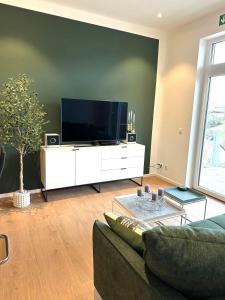 a living room with a large flat screen tv at STAY - City M17 in Tettnang