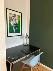 a desk with a laptop and a chair in a room at STAY - City M17 in Tettnang
