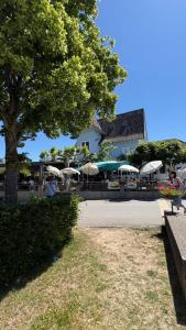 eine Terrasse mit Sonnenschirmen und Tischen und ein Gebäude in der Unterkunft Oumaya in Erlach + 6 Fotos