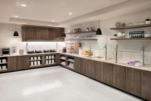 a large kitchen with wooden cabinets and shelves at Residence Inn by Marriott Lenexa City Center in Lenexa
