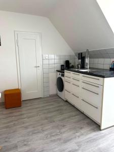 a kitchen with a sink and a washing machine at STAY - City W32 in Friedrichshafen +17 photos