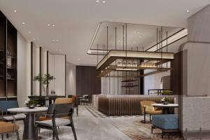 a lobby with tables and chairs and a chandelier at Sheraton Tengzhou in Zhaozhuang