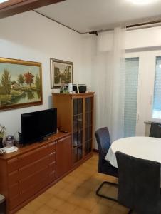 a living room with a table and a tv at Camera singola in appartamento in Pordenone