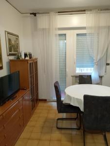 a living room with a table and a television at Camera singola in appartamento in Pordenone +44 photos