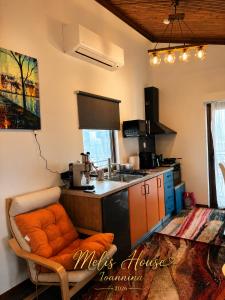 a kitchen with an orange chair and a sink at Melis House - Lake View, 75'' TV Live Football, Free Parking in Ioannina