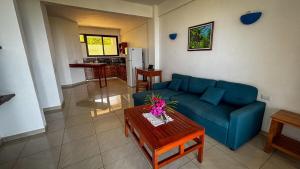 a living room with a blue couch and a table at Samara Ocean View in Sámara