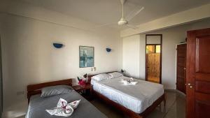two beds in a bedroom with towels on them at Samara Ocean View in Sámara