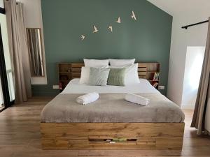 a bedroom with a large bed with two towels on it at La Maison Cabane in Cholet