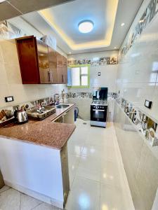 a large kitchen with a counter and a stove at Sea & Pool View Deluxe Chalet - Prime Spot in Badr Resort in El Alamein