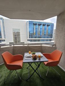a table with a plate of food and two chairs at Cozy Seaside Studio with Private Parking in Nice