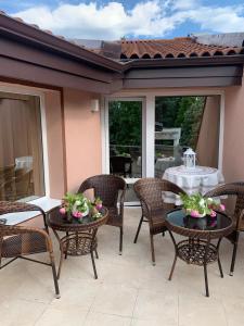 a patio with wicker chairs and tables with flowers on them at Къща Елена in Yagoda