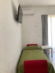 a bedroom with a bed and a tv on the wall at B&B Numero Uno in Bisceglie