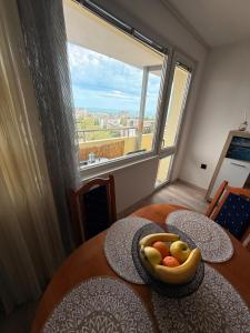 a bowl of fruit on a table with a window at Sunrise Panorama Apartment in Bŭnzareto