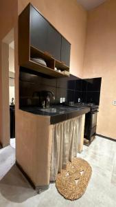 a kitchen with a black counter and a sink at Guajiru Beach House KiteSurf in Trairi