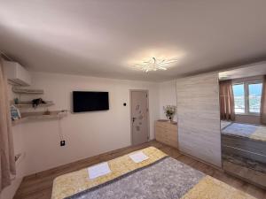 a large white room with a television and a bathroom at Sunrise Panorama Apartment in Bŭnzareto