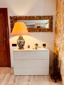 a lamp on top of a dresser with a mirror at Villa Alexandra 1 in Imárcoain +5 photos
