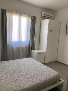 a bedroom with a bed and a cabinet and a window at B&B Numero Uno in Bisceglie