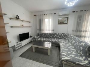 a living room with a large couch and a television at Dedi Apartment 2 in Shkodër +2 photos