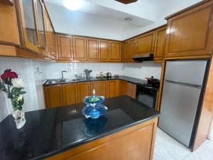 a kitchen with wooden cabinets and a black counter top at Dedi Apartment 2 in Shkodër