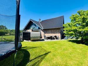 a house with a net in front of a yard at Ferienwohnungen Nahrstedt in Waldeck