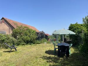 a table and chairs under an umbrella in a yard at La Terrasse des Vignes - Gîte 3 Étoiles Centre Alsace - Logement entier in Blienschwiller