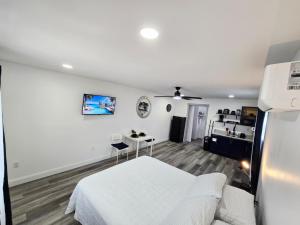 a white bedroom with a bed and a table at Cozy Full Home Experience in Tampa