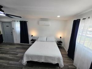 a bedroom with a white bed and a window at Cozy Full Home Experience in Tampa
