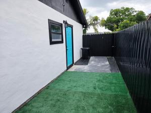 a house with a blue door and a fence at Cozy Full Home Experience in Tampa