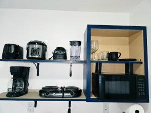 a shelf with a microwave and a coffee maker at Cozy Full Home Experience in Tampa