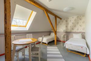a attic room with two beds and a table at Vasekoja Holiday Complex in Möldri