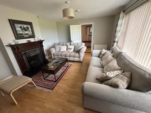 a living room with two couches and a coffee table at Rose Cottage in Portadown