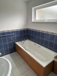 a bathroom with a bath tub and a sink at Rose Cottage in Portadown +29 photos