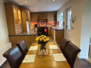 a kitchen with a wooden table with a vase of flowers on it at Rose Cottage in Portadown