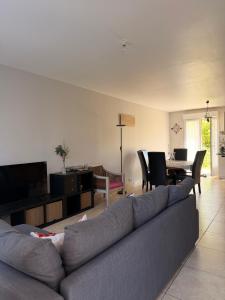 a living room with a couch and a dining room at Magnolia58 in Pontault-Combault