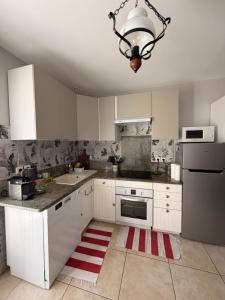 a kitchen with white cabinets and a chandelier at Magnolia58 in Pontault-Combault