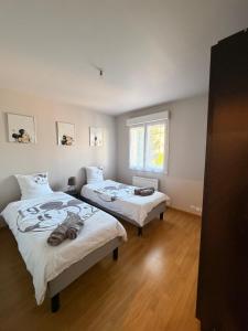 a bedroom with two beds and a window at Magnolia58 in Pontault-Combault