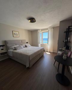 ein Schlafzimmer mit einem Bett und einem großen Fenster in der Unterkunft Accommodation Stella Mare in Bol
