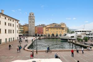 a group of people walking by a river in a city at Lake View Historical Center Apartment - Happy Rentals in Riva del Garda +15 photos