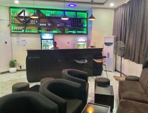 a bar with a piano and chairs in a room at The Tusk Hotel in Kuje