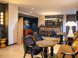 ein Restaurant mit Tischen und Stühlen und einer Bar in der Unterkunft ibis Styles Saint-Quentin in Saint-Quentin