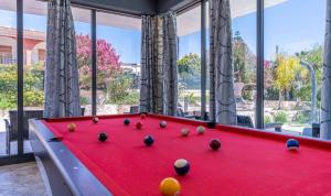 a red pool table in a room with windows at Villa Joel in Fontane Bianche