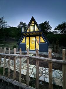 a tiny house with a large window at Camping Temali T&M in Arrëz