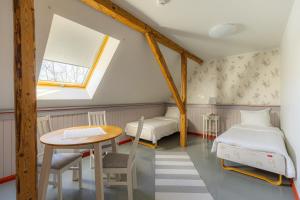 a room with two beds and a table and a window at Vasekoja Historical House near Setomaa in Möldri