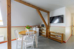 a dining room with a table and white chairs at Vasekoja Historical House near Setomaa in Möldri