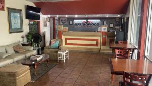a living room with a waiting area with a bar at SPRINGWOOD HOTEL, Opelika I-85 Columbus Pkwy in Opelika