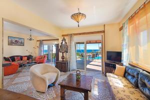 a living room with a couch and a tv at Alkyoni Villa in Lachania