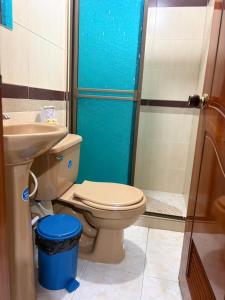 a bathroom with a toilet and a glass shower at Hotel Manhattan City in Duitama
