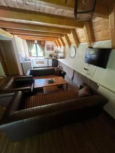a living room with a leather couch and a table at Vikendica Mia in Šipovo
